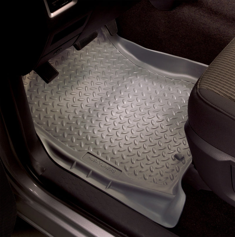 Husky Liners Classic Style: gray diamond-plate front floor liner fitted in a driver footwell beside pedals and seat