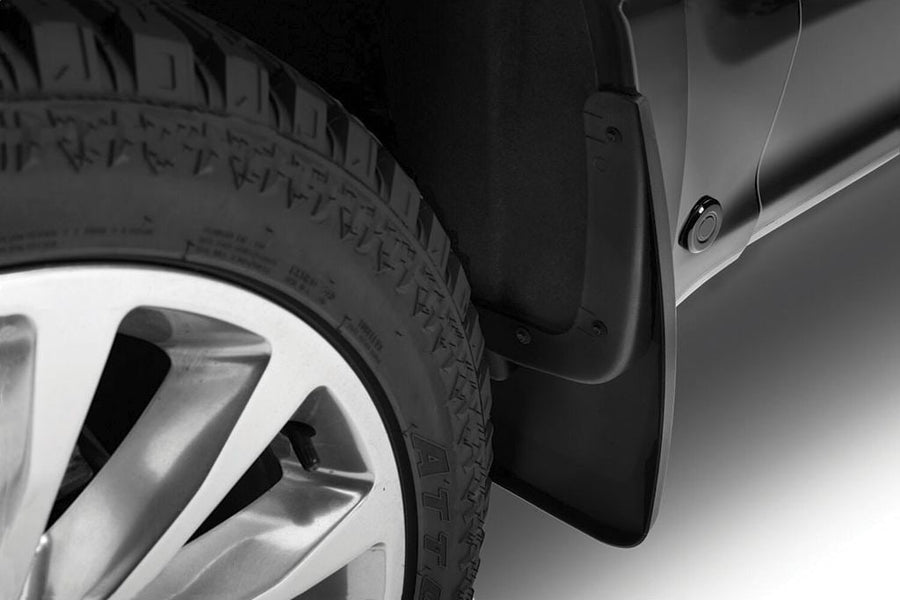 Husky Liners Custom Molded Mud Guards: Close-up of a black mud guard installed behind the front wheel of a dark pickup