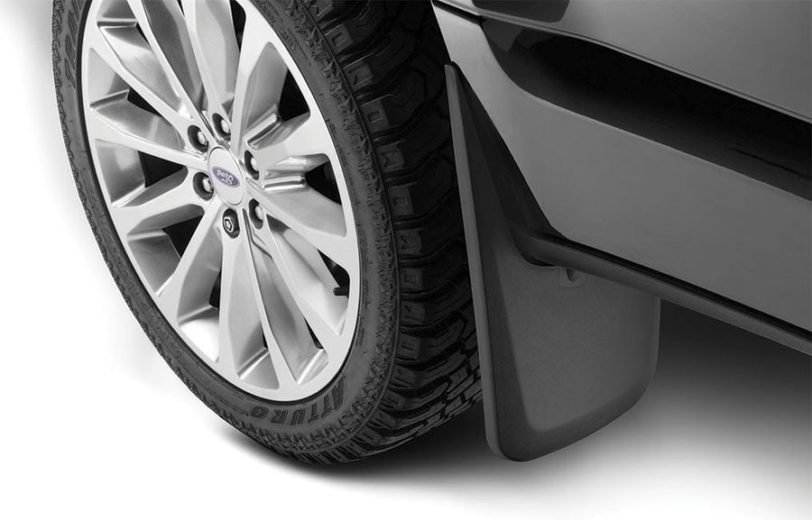 Husky Liners Custom Molded Mud Guards: Black mud guard installed behind the front wheel of a black Ford pickup