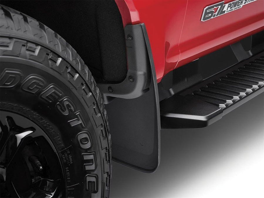 Husky Liners Custom Molded Mud Guards: Black mud guard installed behind the front wheel of a red pickup above the running board