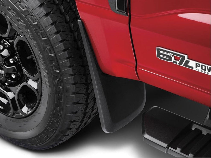 Husky Liners Custom Molded Mud Guards: Close view of a black mud guard installed behind the front wheel of a red pickup