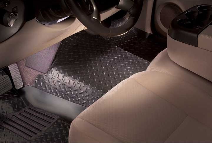 Husky Liners Classic Style Floor Liners: Black diamond-tread front floor liner under the steering wheel and center console of a bench-seat cab
