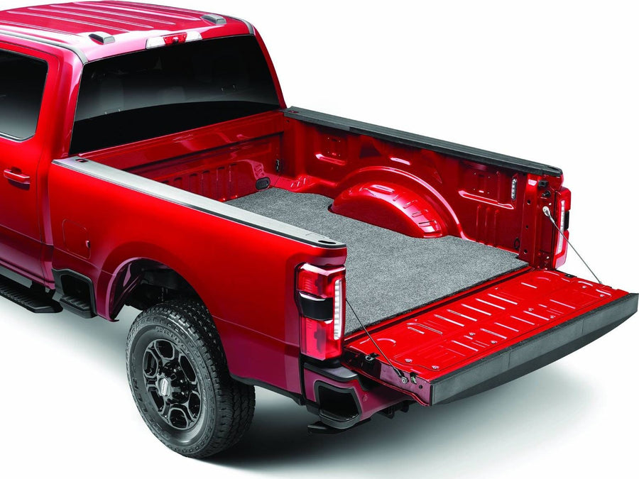 Husky Liners Guardian Comfort Bed Mat: Gray carpet bed mat installed on the floor of a red pickup bed with the tailgate down