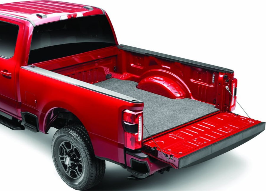 Husky Liners Guardian Comfort Bed Mat: Gray carpet bed mat installed in the bed of a red full-size pickup with the tailgate lowered