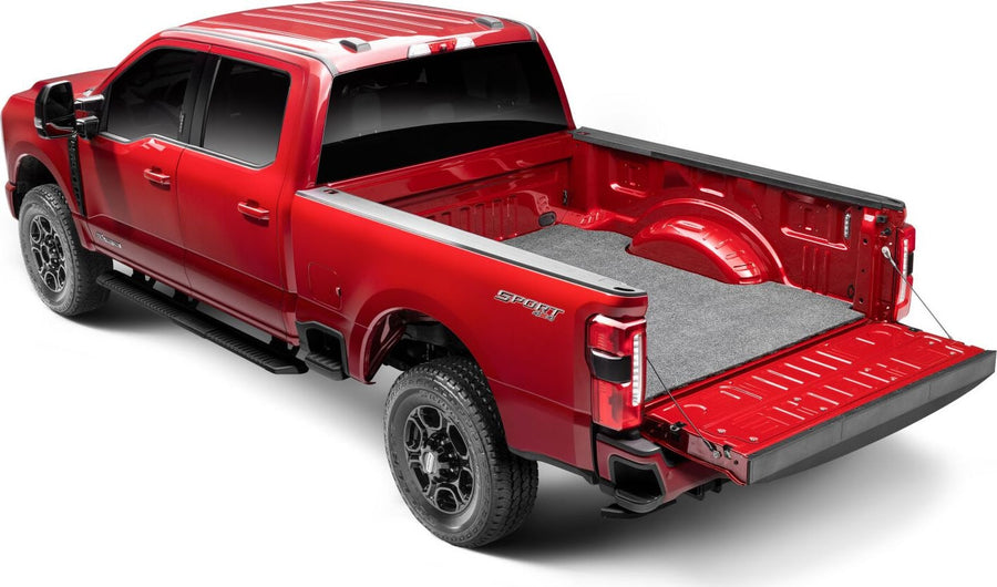 Husky Liners Guardian Comfort Bed Mat: Red full-size crew-cab pickup with a gray carpet bed mat installed and the tailgate lowered