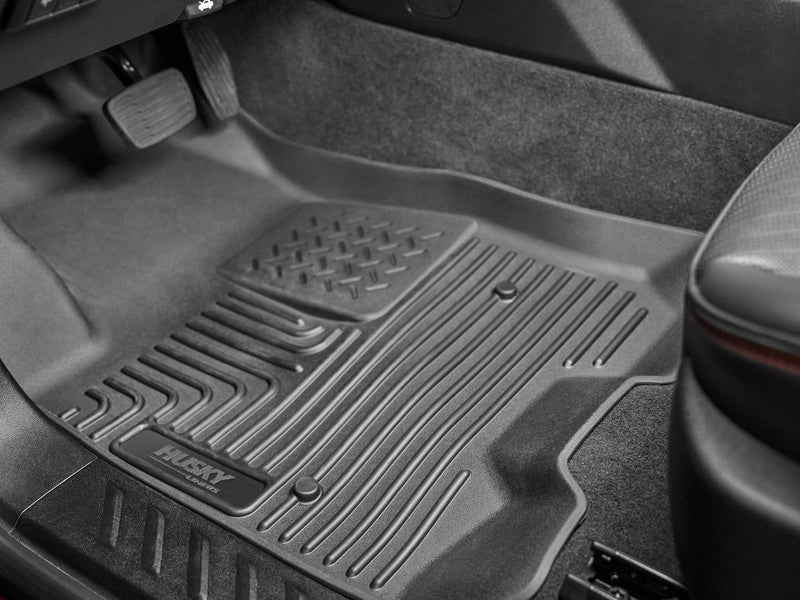 Husky Liners WeatherBeater: black driver-side floor liner with HUSKY LINERS logo installed beneath the pedals (representative image; each liner is molded for its own vehicle)