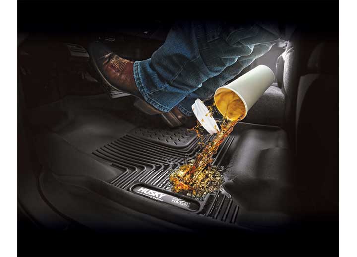 Husky Liners X-act Contour: coffee spilling from a cup onto a black Husky floor liner under a driver's boot