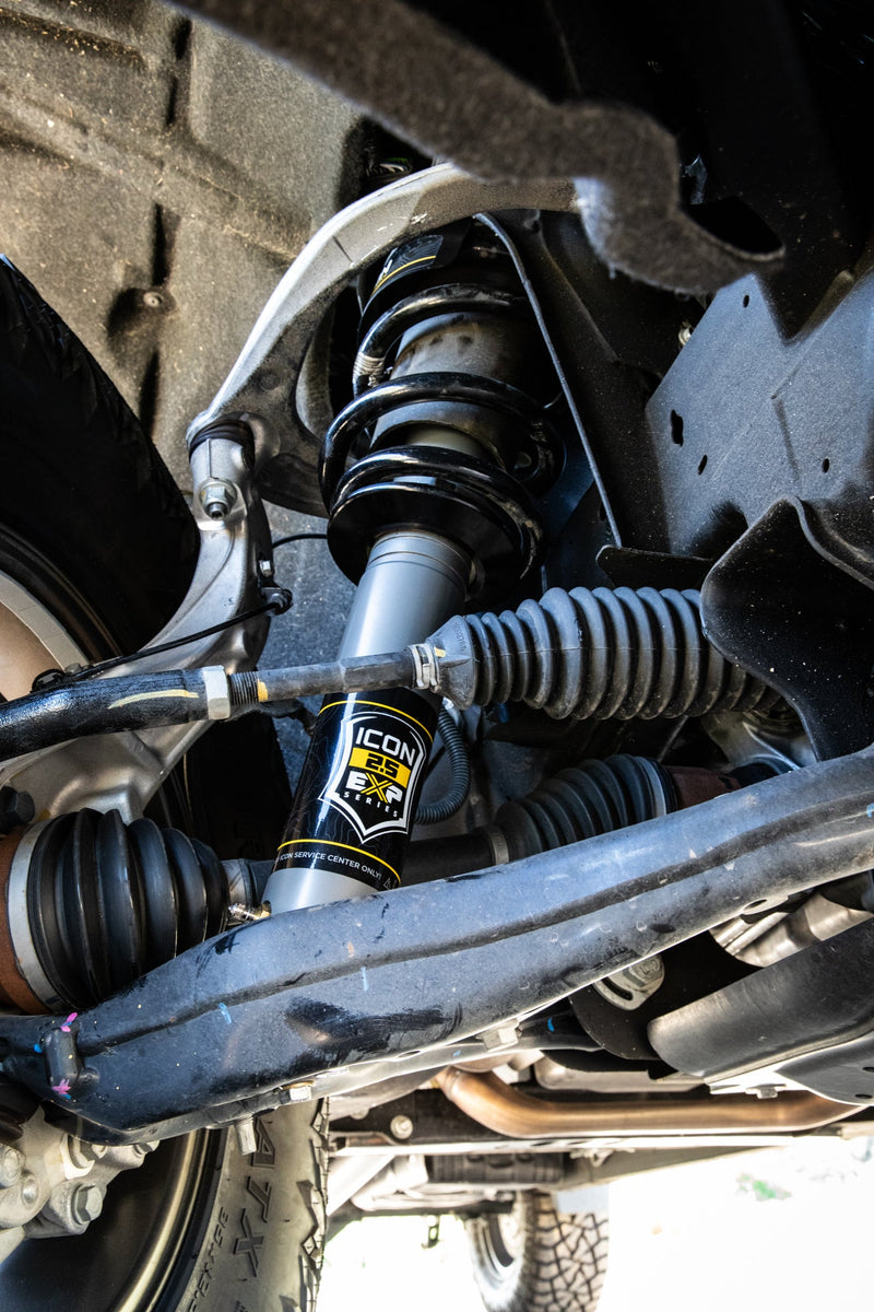ICON Vehicle Dynamics 2.5 EXP Series Coilover on a Chevrolet Silverado 1500 (listing; pixels show GM IFS): underside view of an installed ICON 2.5 EXP front coilover with black spring between the upper control arm, tie rod and CV axle