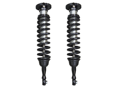 ICON Vehicle Dynamics 2.5 Series Coilover Kit: a pair of ICON 2.5 VS front coilovers with black springs, black top hats and extended lower mounts standing side by side on white