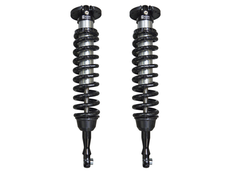 ICON Vehicle Dynamics 2.5 Series Coilover Kit: a pair of ICON 2.5 VS front coilovers with black springs, black top hats and extended lower mounts standing side by side on white