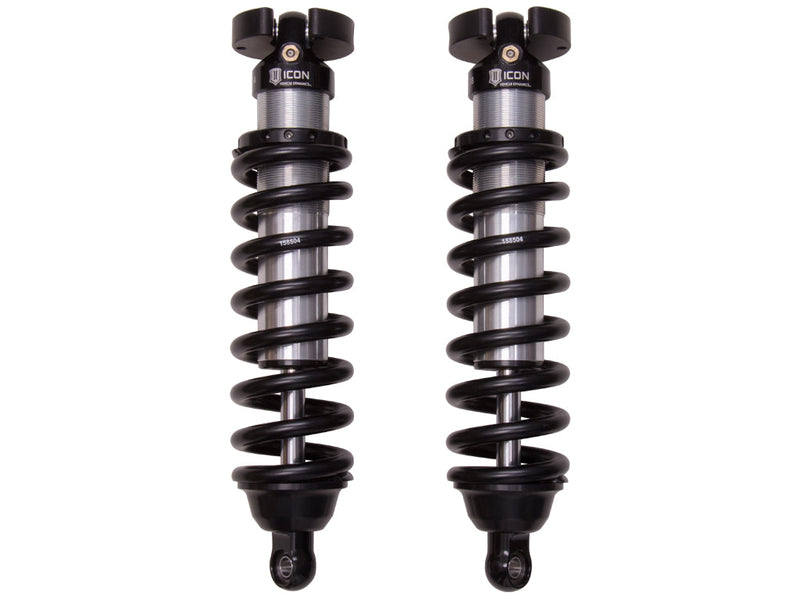 ICON Vehicle Dynamics 2.5 Series Coilover Kit: a pair of ICON 2.5 VS front coilovers with black springs, black top hats and eyelet lower mounts standing side by side on white