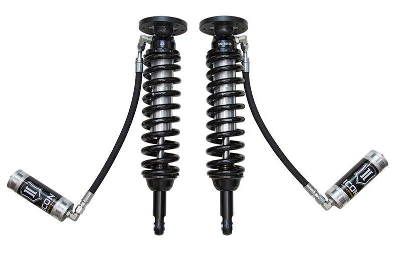 ICON Vehicle Dynamics 2.5 Series Coilover Kit: a pair of ICON 2.5 VS remote-reservoir coilovers with black springs, bar-pin bases and silver ICON reservoirs hanging low on long hoses, on white