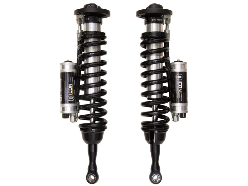 ICON Vehicle Dynamics 2.5 Series Coilover Kit: a pair of ICON 2.5 VS remote-reservoir coilovers with black springs and silver CDC-adjustable reservoirs mounted beside the bodies, on white