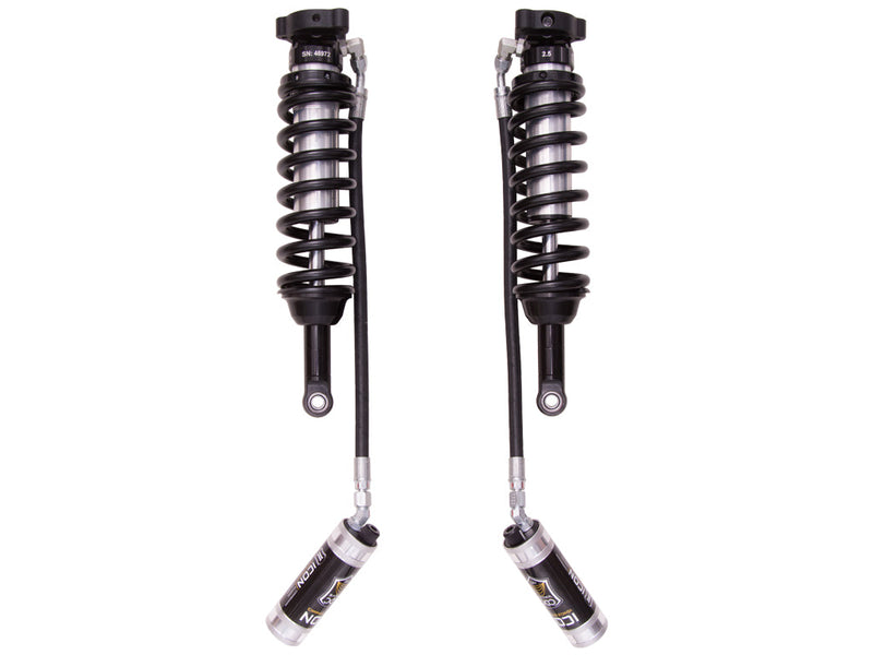 ICON Vehicle Dynamics 2.5 Series Coilover Kit: a pair of ICON 2.5 VS remote-reservoir coilovers with black springs and silver CDC reservoirs hanging low on long hoses, on white