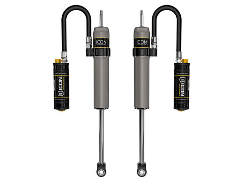 ICON Vehicle Dynamics 2.5 Series Shock Absorbers: rendered pair of gray ICON 2.5 aluminum series shocks with remote reservoirs on looped hoses, stem tops and eyelet bases on white