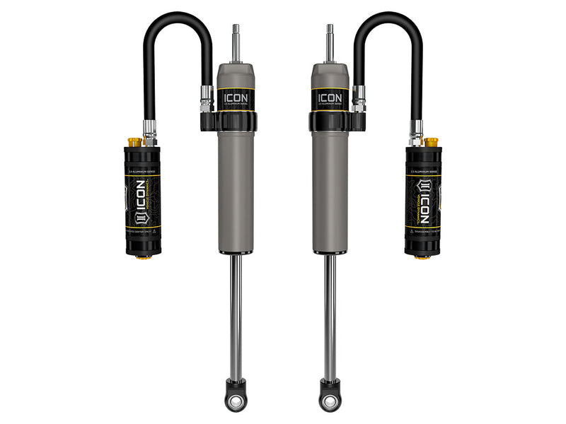 ICON Vehicle Dynamics 2.5 Series Shock Absorbers: rendered pair of gray ICON 2.5 aluminum series shocks with remote reservoirs on looped hoses, stem tops and eyelet bases on white