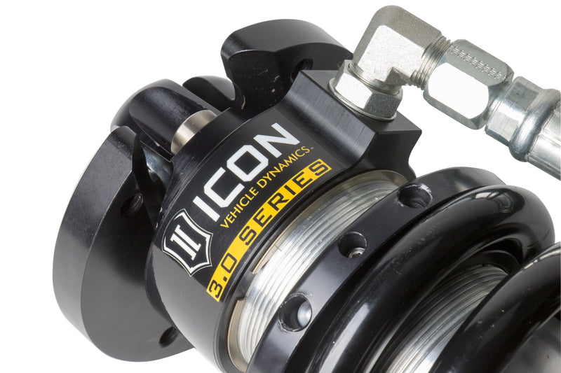 Close-up of the ICON Vehicle Dynamics 3.0 Series Coilover: close-up of an ICON 3.0 Series coilover top cap with ICON Vehicle Dynamics 3.0 Series label, spring seat and braided hose fitting