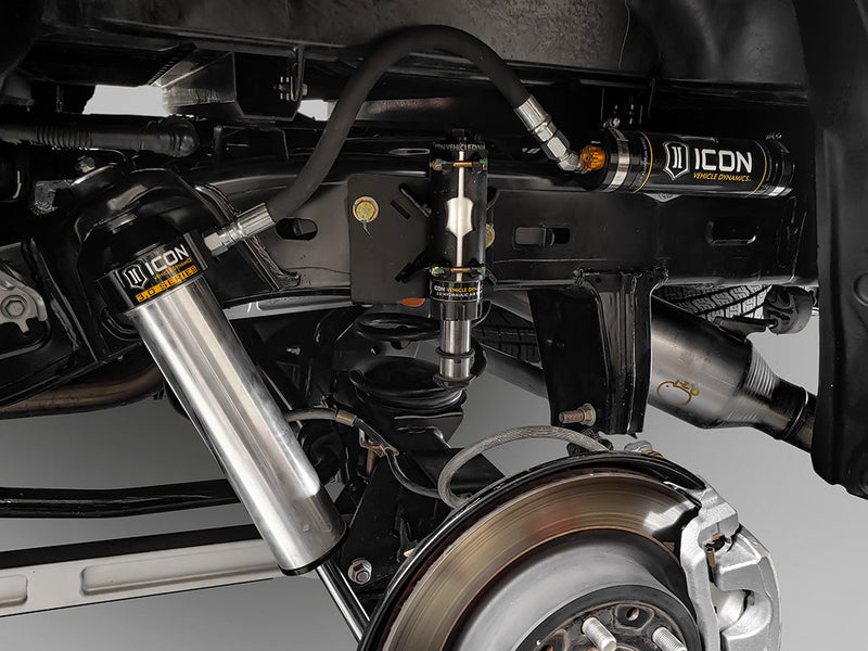 ICON Vehicle Dynamics 3.0 Series Shock Absorbers on a vehicle: installed silver ICON 3.0 Series rear shock beside a rear brake rotor, ICON reservoir and hydraulic bump stop mounted on the frame above
