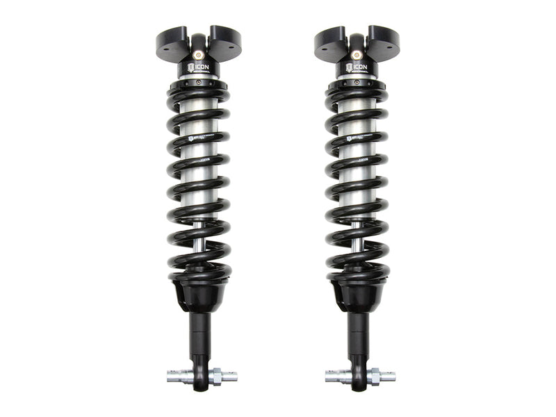 A pair of ICON 2.5 VS internal-reservoir front coilovers with black springs, split-ear tops and bar-pin lower mounts, on white.