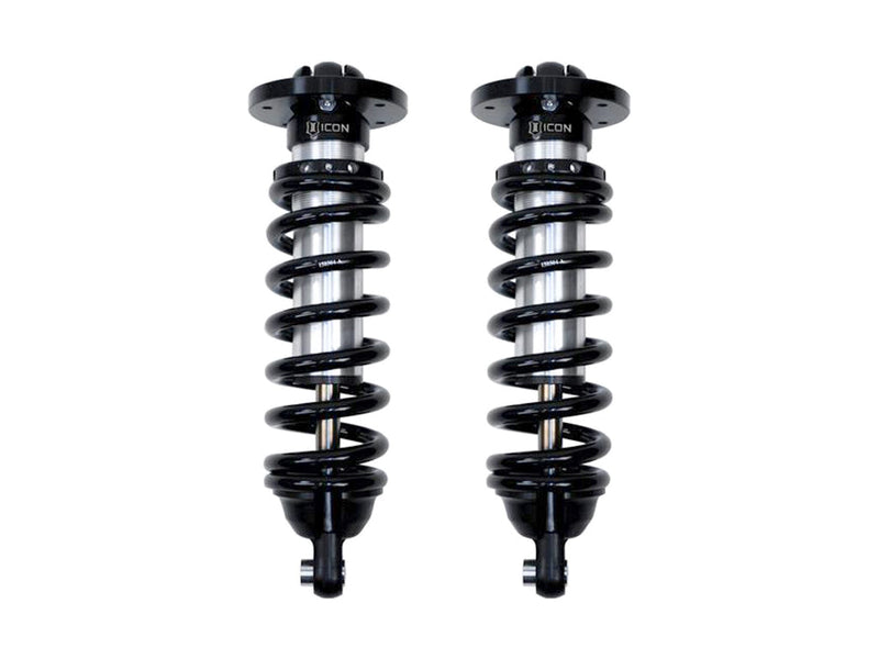 A pair of ICON 2.5 VS internal-reservoir front coilovers with black springs, round tops and eyelet lower mounts, on white.