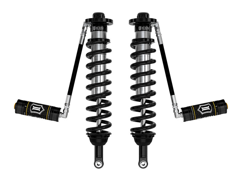 A pair of ICON 2.5 VS remote-reservoir coilovers with black springs and black ICON reservoirs held out horizontally on hoses, on white.
