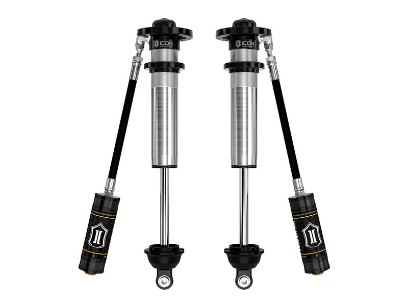 A pair of ICON 2.5 VS remote-reservoir long-travel coilover bodies without springs, reservoirs angled below, on white.