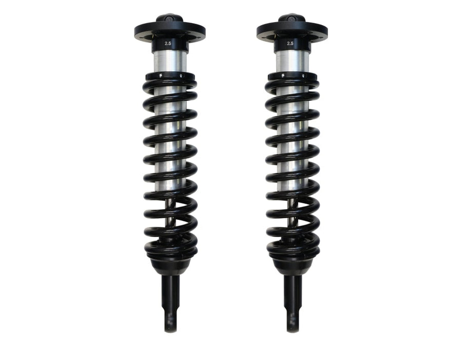 A pair of ICON 2.5 VS internal-reservoir front coilovers with black springs and stem lower mounts, on white.