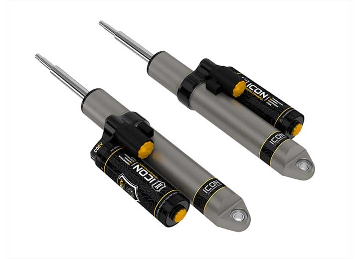 Rendered pair of gray ICON 2.5 aluminum series shocks with CDEV piggyback reservoirs laid diagonally on white.
