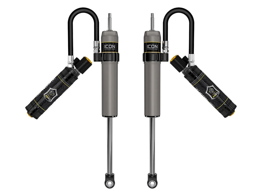 Rendered pair of gray ICON 2.5 aluminum series shocks with CDEV reservoirs angled out on looped hoses, on white.