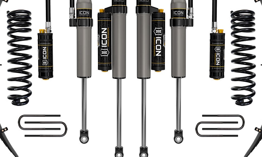 Studio kit layout on white: Stage kit: front coil springs, remote-reservoir and piggyback shocks, rear leaf packs, U-bolts and adjustable track bar.