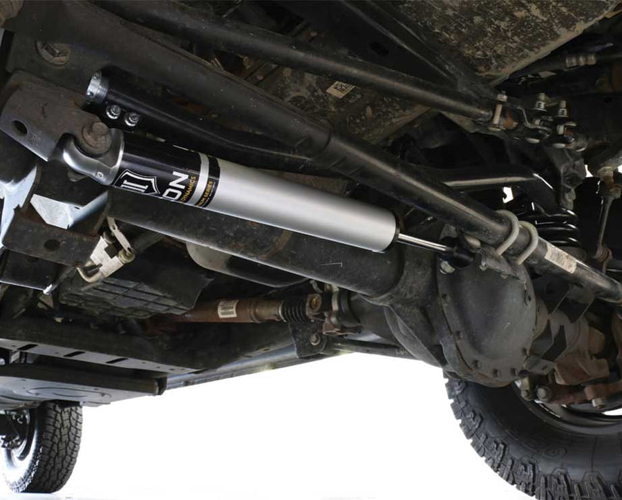 Underside view of an ICON steering stabilizer installed along the tie rod on a solid front axle.