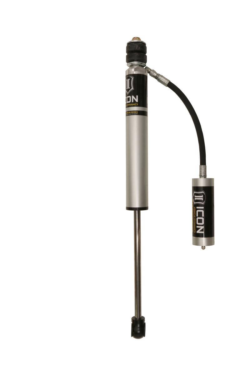 Photograph of a silver ICON 2.0 aluminum series shock with bushing top, hose-linked remote reservoir and eyelet lower end on a light studio backdrop.