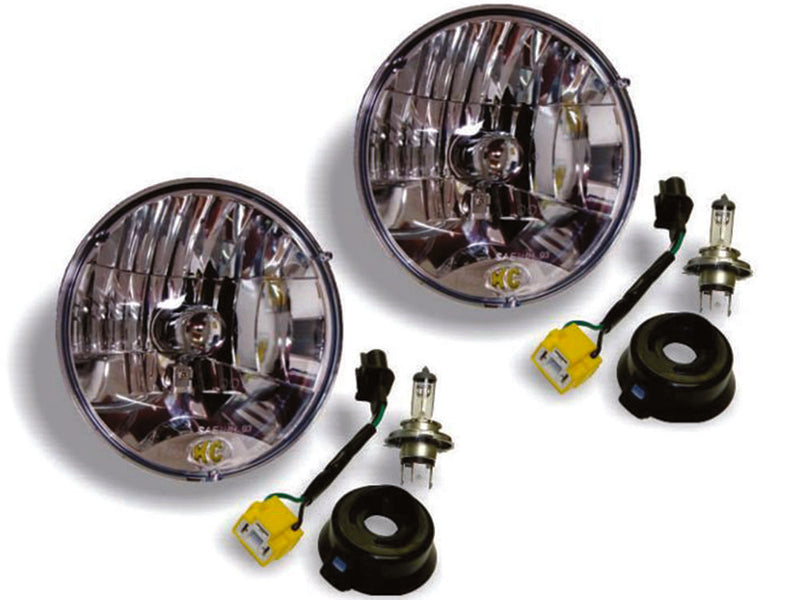 KC HiLiTES 7" H4 DOT Halogen Headlight Pair with H13 Adapters on a studio background: two round 7" clear halogen headlights with H4 bulbs, rubber boots and adapter harnesses on a white background