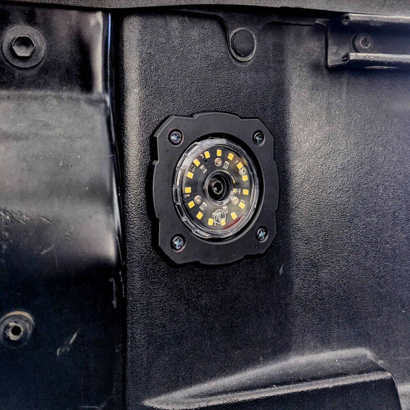 KC HiLiTES Cyclone V2 LED Mount Adapter on a vehicle: black square flange with four screws holding a round clear LED light, flush mounted in a black trim panel