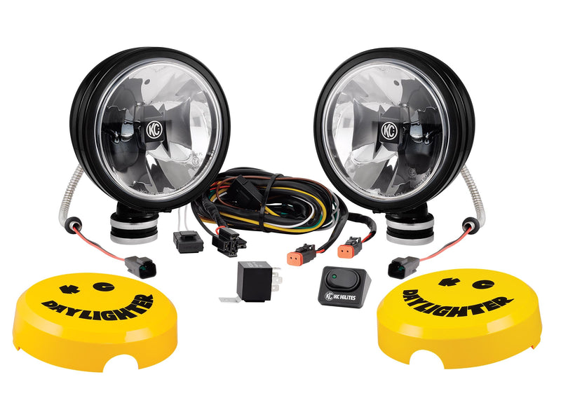 KC HiLiTES Daylighter 6" Gravity LED Light on a studio background: pair of black 6" KC Daylighter Gravity LED lights with wiring harness, relay, rocker switch and two yellow Daylighter covers on a white background