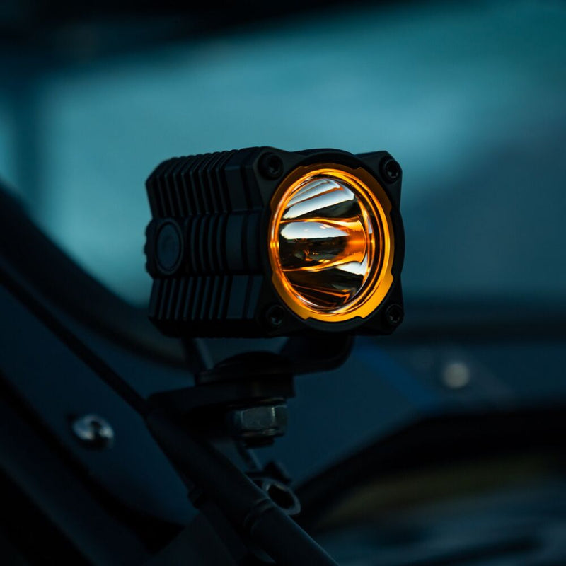 KC HiLiTES FLEX ERA 1 Replacement Lens on a vehicle: FLEX ERA 1 LED light with a gold bezel ring glowing at dusk, mounted on a bracket on an off-road vehicle