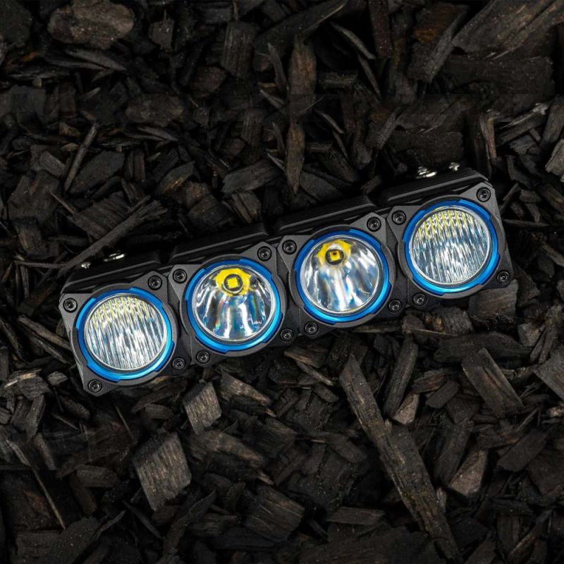 KC HiLiTES FLEX ERA LED Light Bar 10" Segment Bezel Kit on a vehicle: FLEX ERA 10" LED light bar segment fitted with four blue bezel rings, lying on dark wood mulch