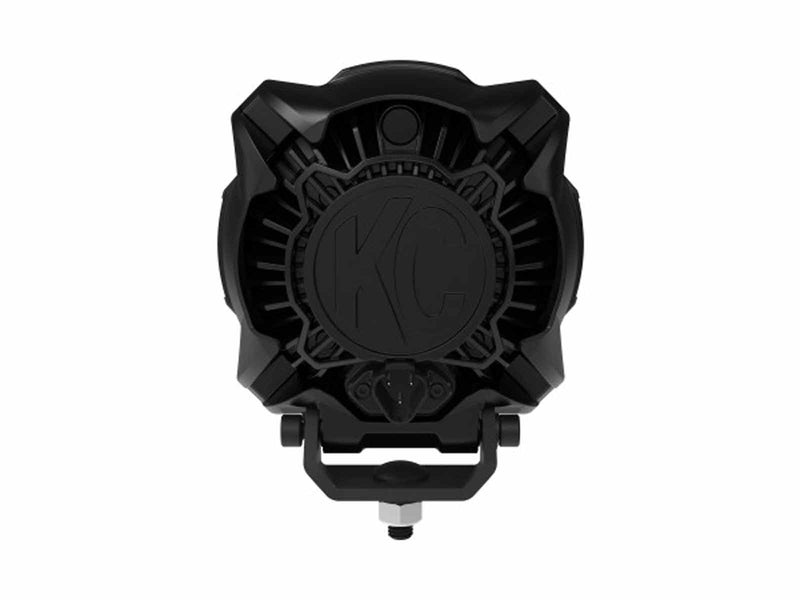Close-up of the KC HiLiTES Gravity Titan 6" LED Light: rear view of a black LED light housing with a cast KC logo on the heat sink and a bracket mount