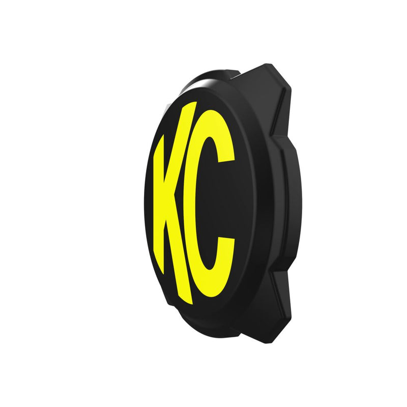 KC HiLiTES Gravity Titan & Pro6 6" Light Cover & Shield on a studio background: black 6" Pro6 light cover with a yellow KC logo at an angle