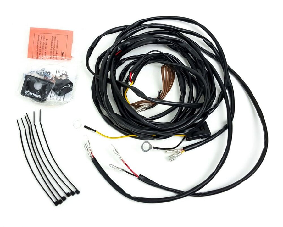 Wiring, Switches & Relays by KC HiLiTES: Wiring harness for two lights with pin terminals, a bagged switch and KC switch plate, screws, an instruction slip and zip ties on a white background