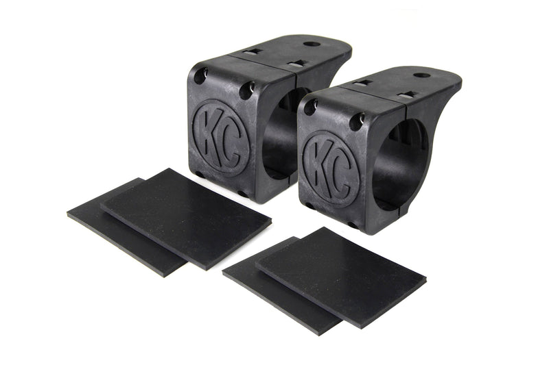 KC HiLiTES Tube Clamp Light Mount on a studio background: pair of black KC tube clamp light mounts, each with two black rubber adjustment shims on a white background