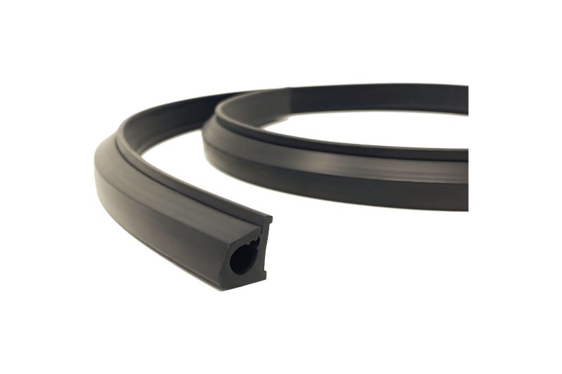 KC HiLiTES Universal Wire Hider, 25 m Bulk on a studio background: curved length of black rubber wire hider strip with its wire channel visible on a white background