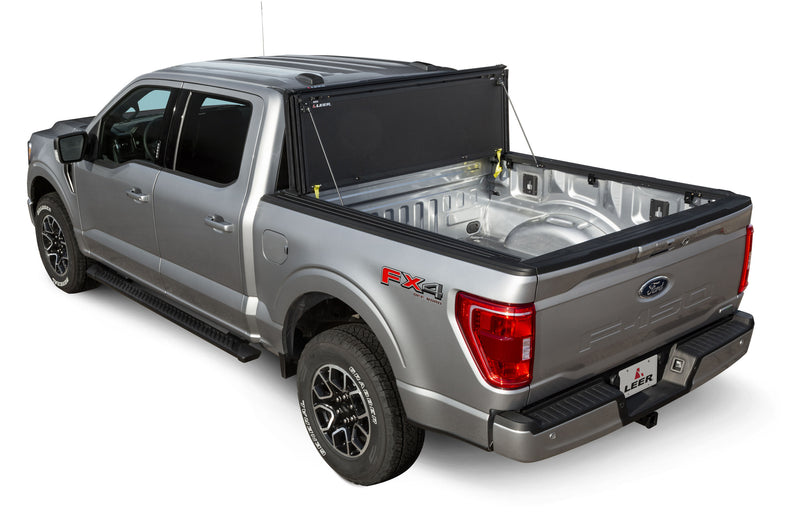 LEER HF350M hard folding tonneau cover on a pickup bed: hard tri-fold cover folded and stood up against the cab, open bed exposed