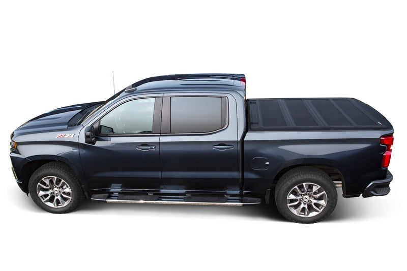 LEER HF650M hard folding tonneau cover on a pickup bed: side profile of a dark blue pickup with a hard cover closed flat over the bed