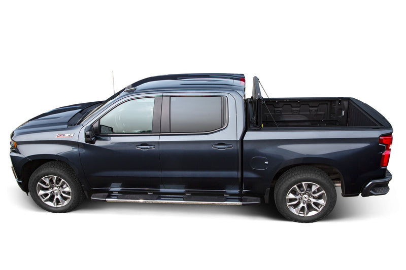 LEER HF650M hard folding tonneau cover on a pickup bed: side profile of a dark blue pickup with the hard folding cover stood upright at the cab, bed open