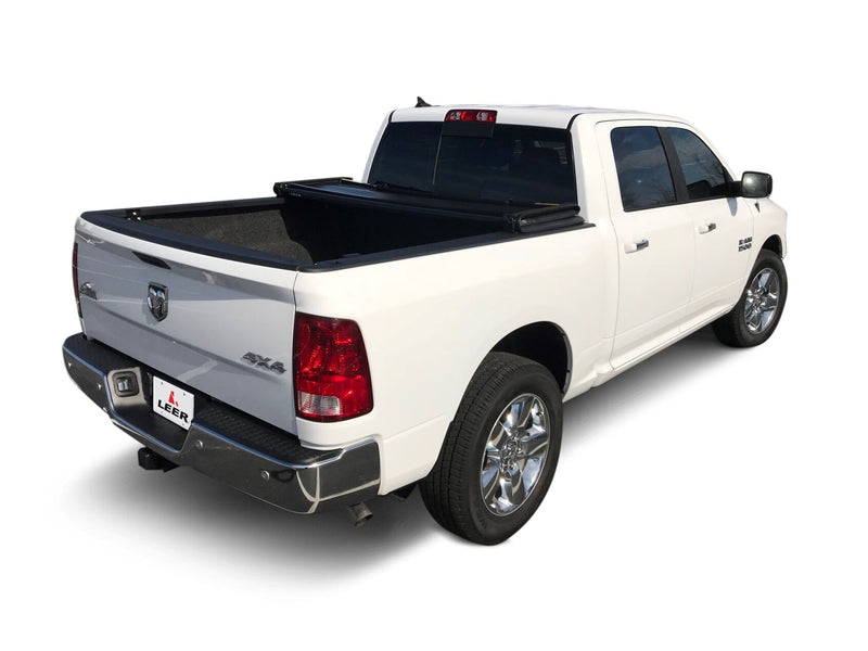 LEER Latitude soft folding tonneau cover on a pickup bed: black soft tri-fold cover folded up against the cab, open bed exposed (bed mat shown, not included)