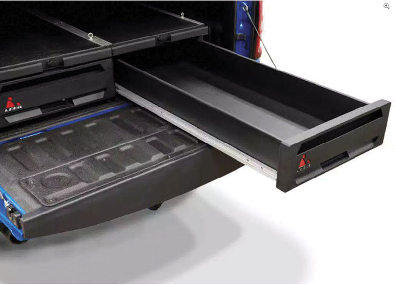 LEER NexStor truck bed drawer unit on a pickup bed: black storage drawer slid open past the tailgate of a pickup bed, second drawer closed beside it