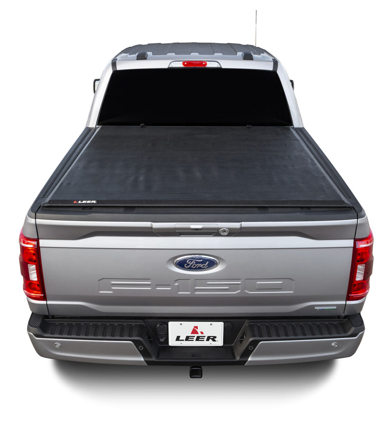 LEER SR250 soft roll-up tonneau cover on a pickup bed: rear view of a silver pickup with a black soft roll-up cover closed flat over the bed