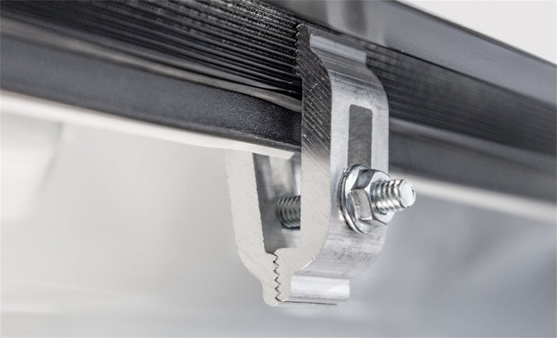 LOMAX Hard Tri-Fold tonneau cover: studio close-up of the aluminum mounting clamp on the rail