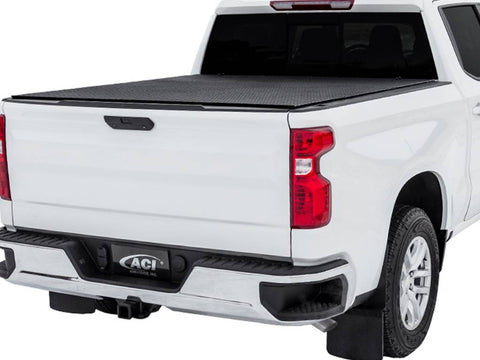 White pickup on white, diamond-pattern black hard tri-fold tonneau cover closed, rear three-quarter view